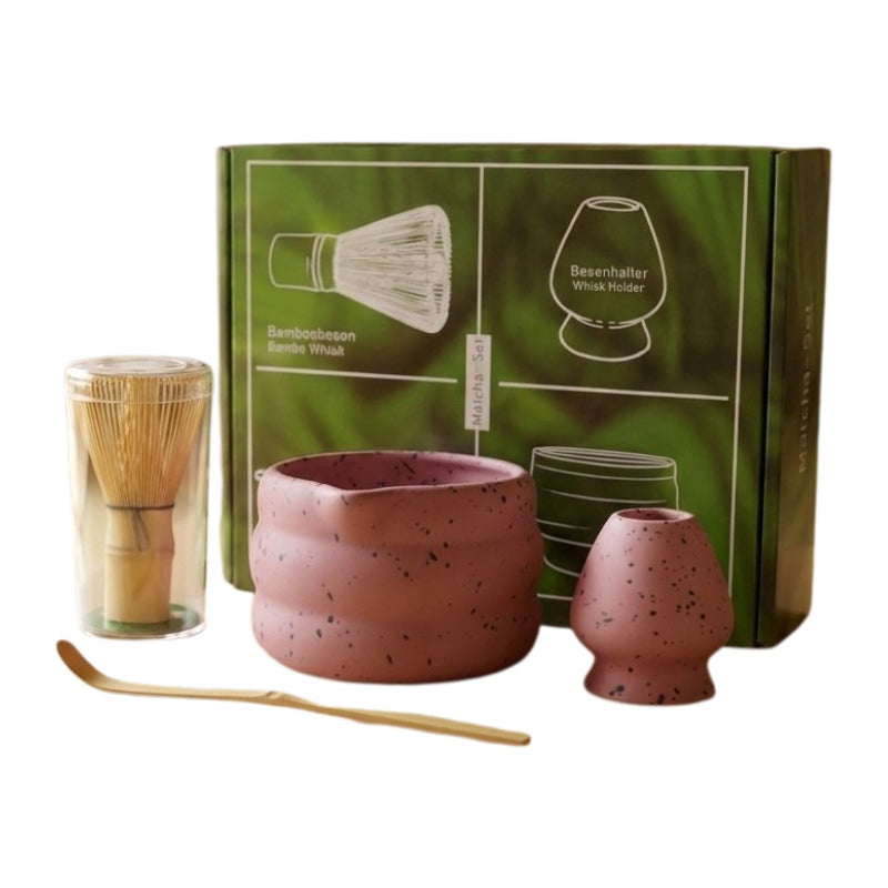 Complete pink matcha gift japanese set including ceramic bowl and bamboo tools with green illustrated gift box on clean white background