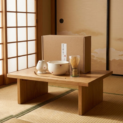 White matcha set tea with red heart pattern bowl and matching whisk holder on tatami table