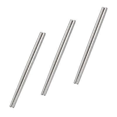Three pairs of polished metal chopsticks arranged at varying lengths on a clean white background