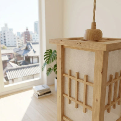 Close up of pendant lamp shoji japanese lantern with natural wood grain near window overlooking temple rooftops