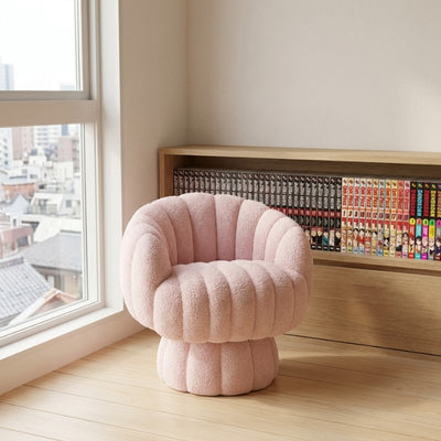 Pink modern Japanese sofa chair in channel tufted bouclé placed by a window overlooking a Japanese city street with a manga bookshelf behind