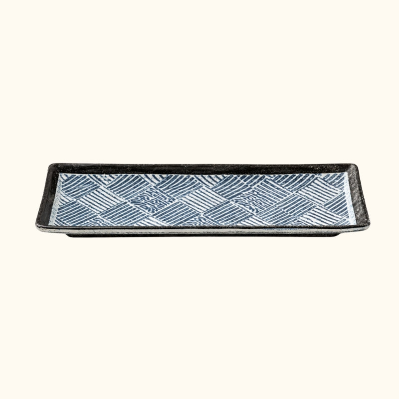 Traditional plate decoration sushi with diagonal line patterns and raised black rim on clean white surface