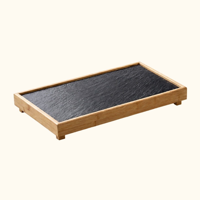 Plate japanese BBQ black slate stone in natural bamboo frame with raised feet displayed on neutral background