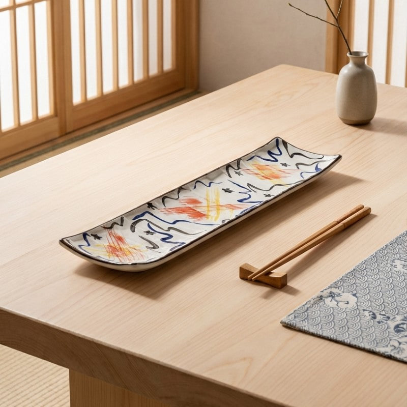 Handpainted ceramic plate sushi set featuring orange and blue brushstroke patterns on natural wood dining table