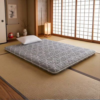 Queen size futon in grey quilted cotton on tatami mat floor in authentic japanese room with shoji screen and andon lamp