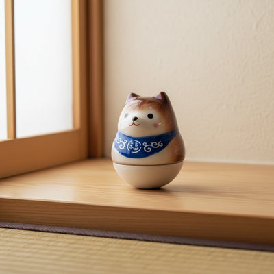 Earthy shiba daruma japanese with blue collar on wooden windowsill in bright traditional Japanese room