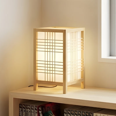 Minimalist shoji lamp in natural pine wood casting soft warm light on shelf above book collection
