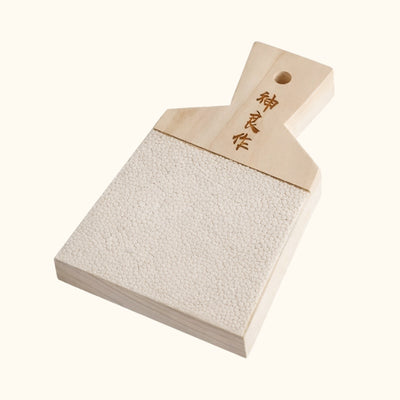 Compact small wasabi grinder featuring traditional Japanese characters and fine sharkskin grating surface