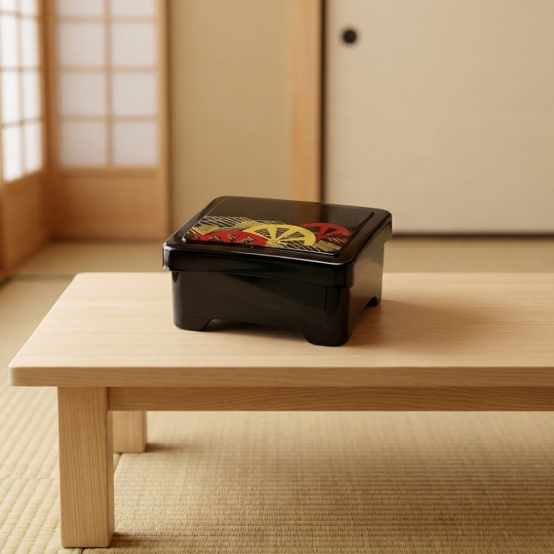 Dark sushi bento box black with clear lid showing golden pattern on low table in Japanese interior with tatami mat
