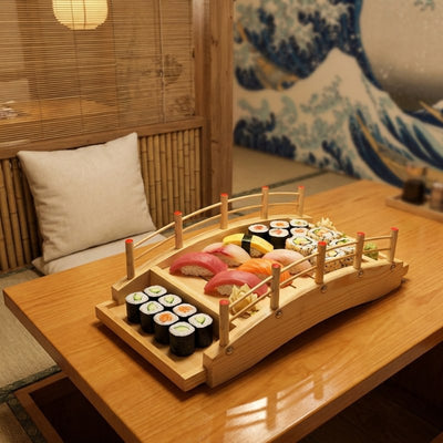 Sushi boat wooden bridge presentation displaying nigiri salmon tuna and maki rolls in zen restaurant with Great Wave artwork