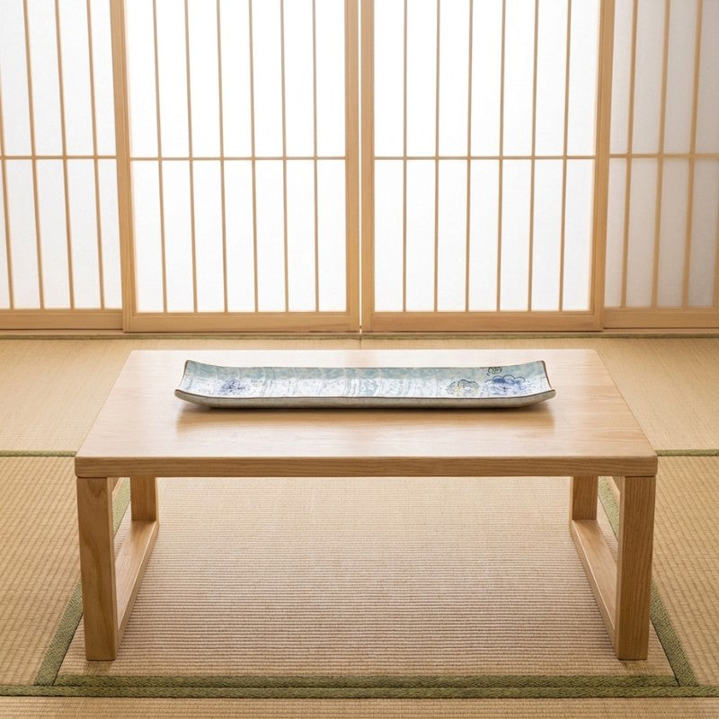 Authentic sushi ceramic plate displayed on wooden chabudai table in traditional tatami room with shoji paper screens