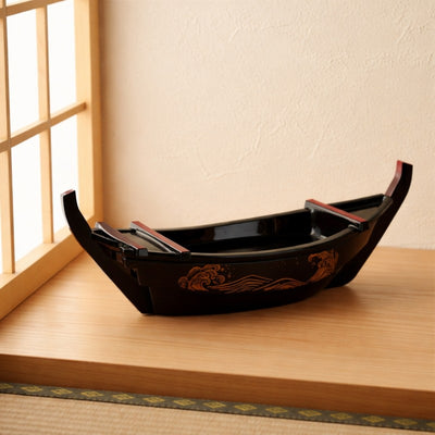 Sushi sushi boat black lacquer with traditional wave design on low table near rice paper screen in Japanese room