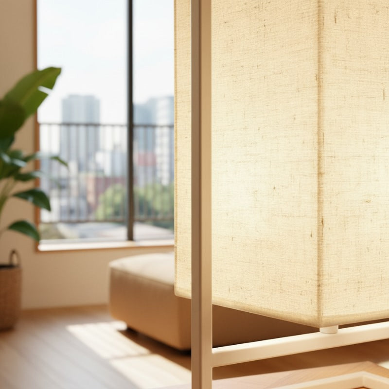 Close up detail of table lamp japanese cloth shade showing natural linen texture and white frame structure with cityscape view through window