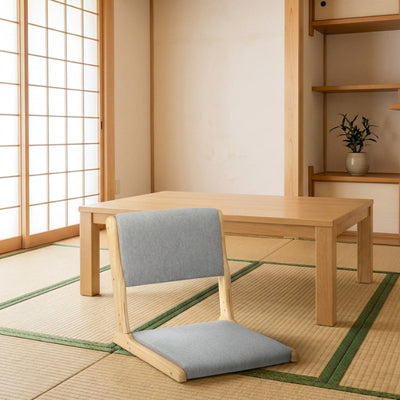 Tatami chair zaisu with gray upholstery beside low wooden table on tatami floor in traditional room with shoji screen