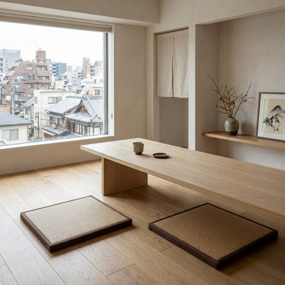 Tatami japanese mattress pair with woven surfaces beside wooden table overlooking urban rooftops with noren and sumi-e art