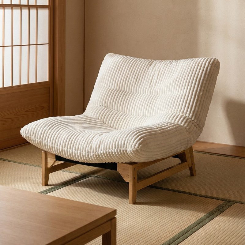 Traditional Japanese sofa with cream ribbed upholstery and wooden legs on tatami floor near shoji screen in minimalist traditional interior