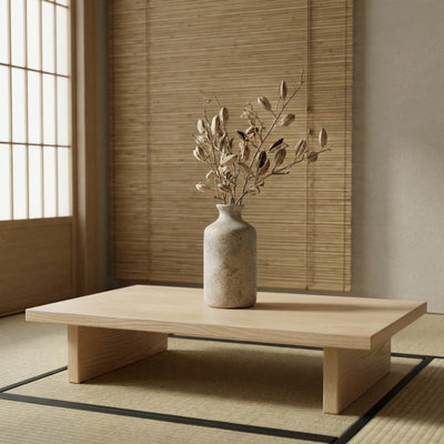 Handcrafted vase vintage ikebana with handle holding dried botanical arrangement on wooden table near bamboo blind