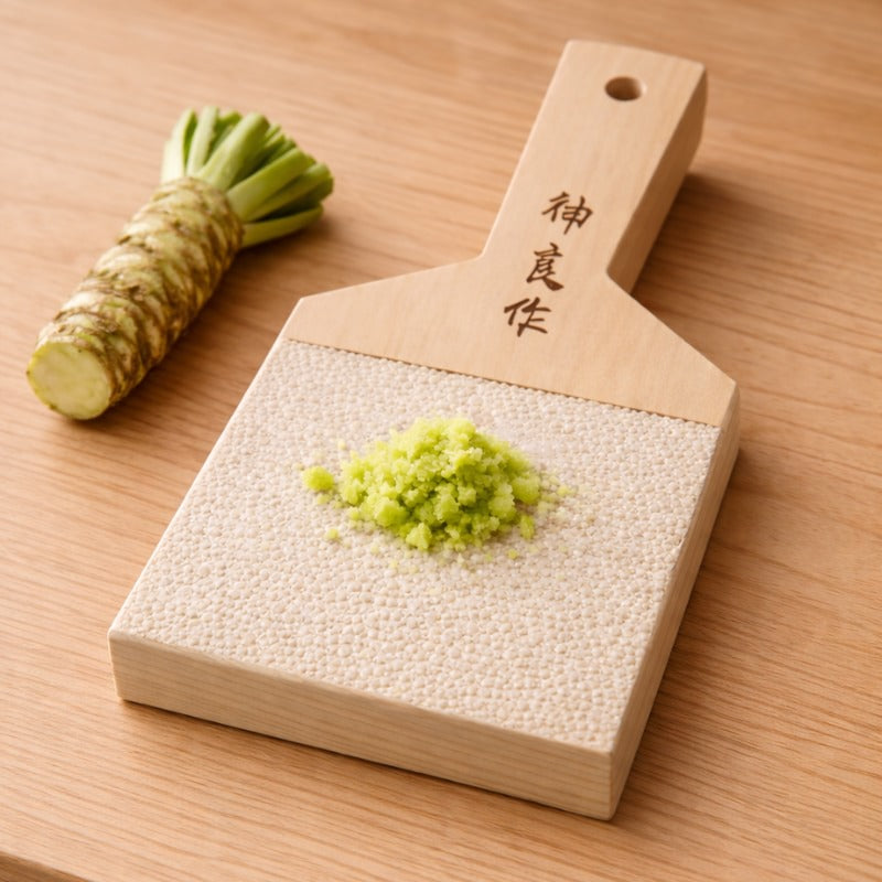 Large wasabi grinder big with fresh wasabi root and grated green paste on sharkskin surface with Japanese kanji