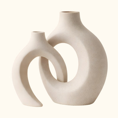 Elegant white japanese vintage vase duo with curved hollow forms on clean neutral background