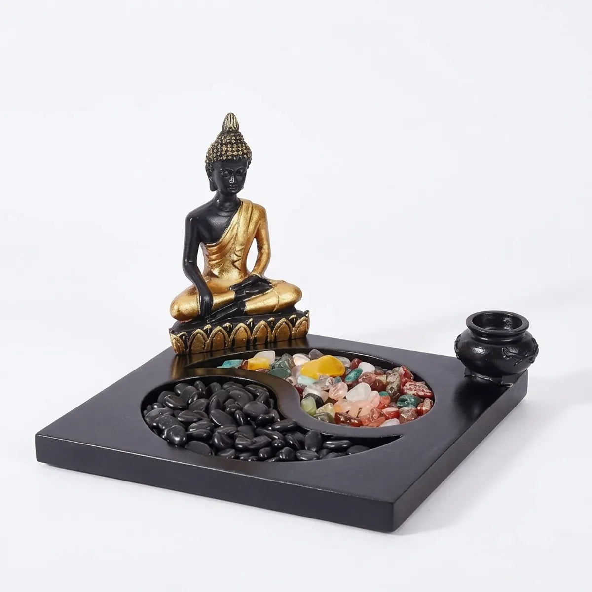 The Japanese zen rock garden shown alone on a white background, with its Buddha figure, black pebbles, colored stones and small censer.