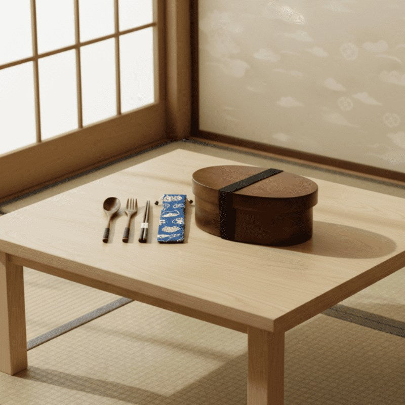Oval dark wooden bento box japanese design with utensils and patterned pouch resting on low table with tatami mat catching soft morning rays