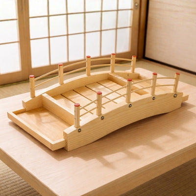 Wooden sushi boat bridge style platform with curved railings and traditional Japanese construction on minimalist table
