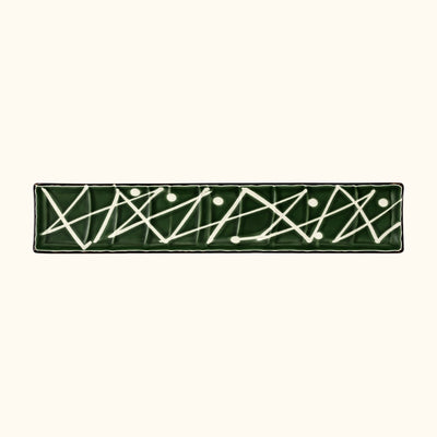 Close-up of zigzag plate sushi featuring abstract geometric white lines on hunter green ceramic surface
